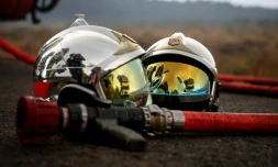 Deux casques de pompier et une lance à incendie gisent au sol alors qu'un incendie de forêt fait rage à Saint-Jean-d'Illac, à environ 30 km de Bordeaux, le 26 juillet 2026