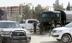 Des forces syriennes et des soldats russes, alliés de Damas, à l'entrée de la localité de Harasta, prÚs de Damas, que des rebelles et des civils doivent quitter jeudi aprÚs un accord régime-insurgés.