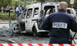 Un policier devant la carcasse d'un véhicule de police incendié à Viry-Chatillon le 8 octobre 2016