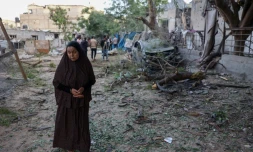 Une Palestinienne se tient prÚs d'un bùtiment détruit à Rafah, dans le sud de la bande de Gaza, le 22 mai 2024