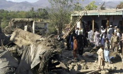 Des policiers et habitants au milieu des ruines de maisons détruites par un puissant séisme, le 27 octobre 2015 à Lower Dir, au Pakistan
