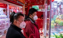 Des clients portent un masque de protection dans une boutique de Pékin, le 29 janvier 2020 en Chine