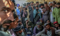 Des hommes rassemblés autour de sacs contenant de l'héroïne et du haschisch en vérifient la qualité, sur un marché à l'extérieur de Kandahar, en Afghanistan, le 24 septembre 2021