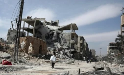 Des Syriens fuyant la localité de Hammouriyé et ses bâtiments détruits par les bombardements face à l'avancée des forces du régime, le 15 mars 2018