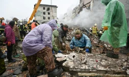 Des habitants nettoyent des débris après une frappe de missile russe sur des immeubles d'habitation dans la ville ukrainienne de Poltava, le 1er février 2025