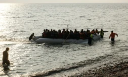 Des migrants sur un canot pneumatique débarquent sur l'île de Lesbos, le 20 mars 2016
