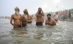 Des pèlerins hindous se baignent dans les eaux froides du confluent des fleuves sacrés du Gange, de la Yamuna et de la Sarasvati à Prayagraj en Inde, le 13 janvier 2025