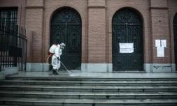 Un employé désinfecte les abords d'un bureau de vote à la veille du premier tour des élections présidentielles et législatives, à Lima le 10 avril 2021