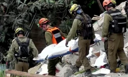 Image tirée d'une vidéo d'AFPTV montrant des équipes de secours sortant les corps de victimes des décombres d'un immeuble résidentiel détruit par une attaque de missile iranienne dans la ville de Haïfa, dans le nord d'Israël, le 6 avril 2026