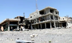 Des habitants inspectent des bâtiments endommagés par les raids nocturnes  du régime dans la ville de Nawa, dans la province de Deraa, le 18 juillet 2018
