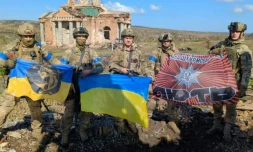 Photo diffusée par Andriy Yermak, chef de cabinet du président ukrainien, le 17 septembre 2023 , montrant des soldats ukrainiens avec des drapeaux nationaux devant un bâtiment détruit dans le village de Klichtchiïvka, dans la région de Donetsk