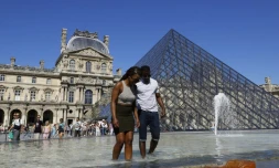 Les touristes qui ont bravé le soleil ont souvent fait trempette dans les fontaines parisiennes, comme ici devant la pyramide du Louvre