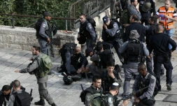 Un policier israélien agressé au couteau par un Palestinien reçoit les premiers soins entouré par ses collèges, le 10 octobre 2015 près de la Vieille ville de Jérusalem