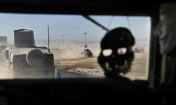 Un masque de crâne et un masque des Anonymous pendent à l'intérieur d'un véhicule blindé des Forces spéciales irakiennes, le 24 novembre 2016 au nord-est de Mossoul