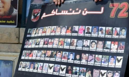 Une personne tient une affiche montrant les portraits des victimes des émeutes de Port Said en Egypte, le 9 juin 2015 au Caire