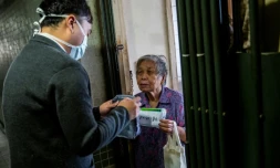 L'élu local pro-démocratie Eason Chan distribue des masques et produits d'hygiène dans un immeuble à Hong Kong le 14 mars 2020