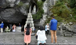 Des pĂšlerins prient le 15 aoĂ»t 2017 devant la grotte de Massabielle Ă Lourdes, oĂč Bernadette Soubirous dit avoir vu des apparitions de la Vierge Marie