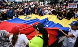 Des manifestants brandissent un drapeau vénézuélien géant lors d'un rassemblement en soutien au président vénézuélien déchu Nicolas Maduro à Caracas, le 10 janvier 2026