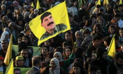 Un drapeau à l'effigie d'Abdullah Öcalan est brandi par des Kurdes syriens venus écouter son message, à Qamishli, dans le nord-est de la Syrie, le 27 février 2025
