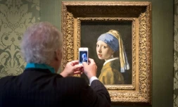 Un visiteur du musée Mauritshuis prend en photo "La Jeune Fille à la perle" de Vermeer, à La Haye, aux Pays bas, le 20 juin 2014