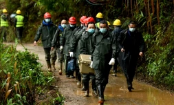 Des sauveteurs transportent une boĂźte prĂšs du site oĂč un Boeing 737-800 de la China Eastern Airlines s'est Ă©crasĂ©, le 24 mars 2022 Ă Wuzhou, dans le sud de la Chine