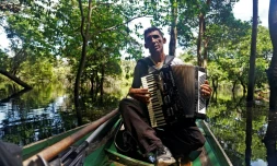 Le Brésilien Eder Rodrigues do Nascimento chante des chansons contre la déforestation et le changement climatique sur la rivière Jurua dans la région de Carauari au Brésil le 14 mars 2020