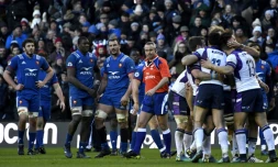 Les joueurs du XV de France (g) dépités regardent les Ecossais se congratuler aprÚs leur victoire aux Six Nations à Murrayfield, le 11 février 2018