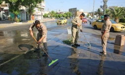 Des forces de sécurité irakiennes nettoient les rues à Bagdad aprÚs la levée du couvre-feu imposé en raison de manifestations, le 5 octobre 2019
