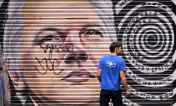 Un homme passe devant une peinture murale représentant le fondateur de WikiLeaks, Julian Assange, dans une ruelle de Melbourne, en Australie, le 26 mars 2024