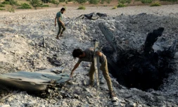 Des rebelles sériens près d'un avion du régime abattu près de Khan Cheikhoun, dans le sud de la procince d'Idleb, le 14 août 2019 en Syrie