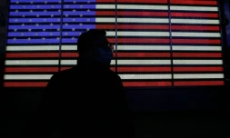 Une personne devant un panneau affichant le drapeau américain à Times Square, à New York, le 12 janvier 2022