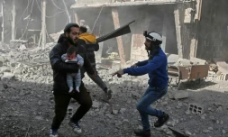 Un Syrien porte un bébé blessé dans la localité de Hamouria, dans l'enclave rebelle de la Ghouta orientale prÚs de Damas, cible de violents bombardements du régime, le 19 février 2018