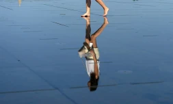 Reflet d'une femme sur le mirroir d'eau dans le centre de Bordeaux où la population vient se rafraîchir, le 19 juin 2017