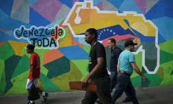 Des personnes passent devant une fresque murale faisant campagne pour un référendum demandant aux Vénézuéliens d'envisager l'annexion de la région de l'Essequibo administrée par le Guyana voisin, à Caracas, le 28 novembre 2023