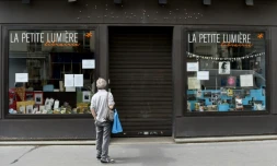 Un passant arrĂȘtĂ© devant une librairie fermĂ©e, le 17 avril 2020 Ă Paris
