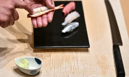Le maßtre du sushi Toshiya Matsushita applique du wasabi frais à l'intérieur d'une crevette dans son restaurant de Tokyo, le 1er décembre 2020