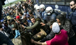 Des migrants tentent de percer une barricade installée par la police grecque à Idomeni, à la frontière avec la Macédoine, le 11 avril 2016