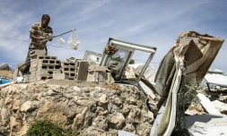 Un Palestinien récupère des objets dans les décombres d'une maison démolie dans le hameau de Khallet Al-Dabaa, en Cisjordanie occupée, le 6 mai 2025, après la destruction par les forces israéliennes des habitations de ce village