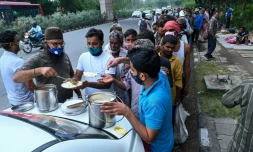 Des Indiens sans domicile fixe, notamment des travailleurs journaliers, font la queue pour une distribution de nourriture à New Delhi le 20 mai 2021