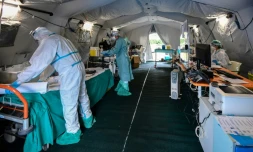 Des membres du personnel médical se préparent à accueillir des patients sous une tente médicale de "triage" installée devant un hôptail à Brescia, le 13 mars 2020 à Italie