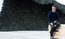 L'artiste français Jean-Michel Othoniel devant l'une de ses œuvres composées de 10 000 briques de verre noir en forme de vague, intitulée "Big Wave", dans son atelier de Montreuil, près de Paris, le 27 février 2025