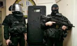 Des policiers de la BRI posent à côté d'un bouclier le 17 novembre 2015 à Paris sur lequel on voit les impacts de balles des terroristes, lors de l'intervention au Bataclan