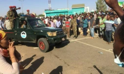 Des manifestants soudanais entourent un véhicule de l'armée à Khartoum, le 8 avril 2019