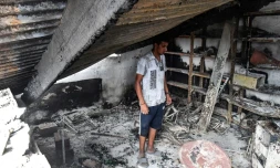 Un habitant dans les décombres de sa maison détruite par un feu de forêt, le 18 août 2022 à El Kala, en Algérie