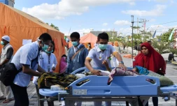 Des équipes médicales prennent en charge des blessés dans un hôpital de fortune, le 6 août 2018 à Mataram, après un séisme meurtrier sur l'île de Lombok, en Indonésie