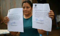 Rosa Romero montre deux assignations du tribunal de Jucuaran pour libĂ©rer la parcelle oĂč elle vit sur la plage d'El Higueron, le 20 juillet 2024 au Salvador