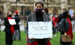 Une manifestante, chanteuse d'opéra, tient une pancarte "Entendez ma voix", le 30 octobre 2020 à Londres