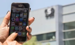 Une femme montre son téléphone devant le siège de l'entreprise NRO, qui a conçu un logiciel espion, le 28 août 2016 à Herzliya, en Israël.