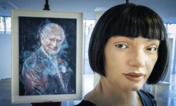 Le robot artiste gynoïde Ai-Da devant le portrait du roi Charles III qu'il a peint, exposé en marge du Sommet mondial AI for Good organisé par l'Union internationale des télécommunications (UIT) à Genève, le 9 juillet 2025