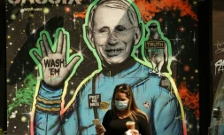 Des passants marchent devant une fresque représentant le Dr Anthony Fauci, directeur de l'Institut américain des maladies infectieuses, le 16 septembre 2020 à New York